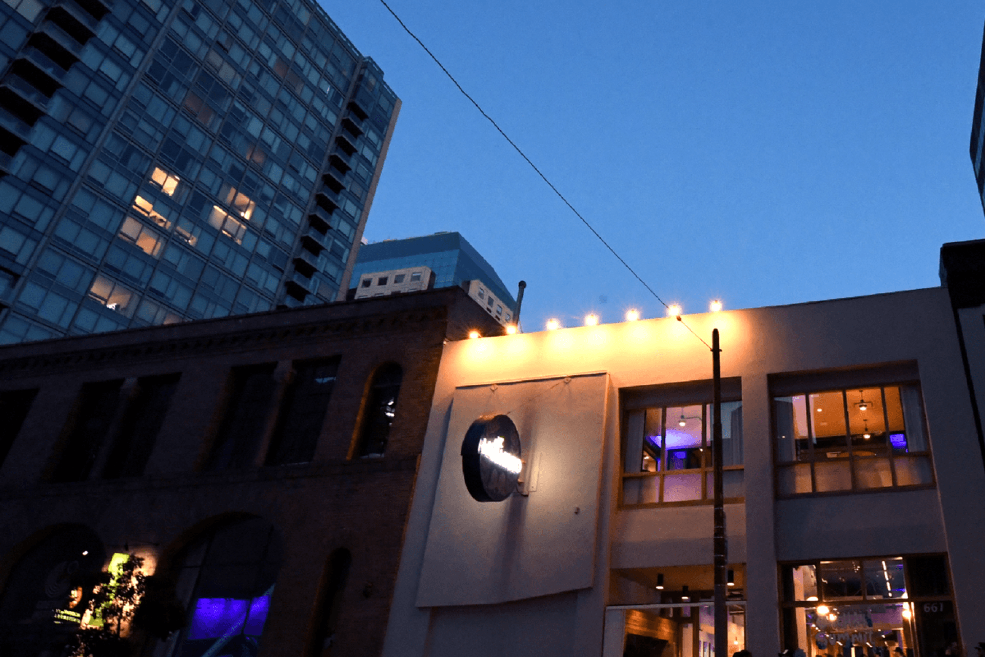 The Howard exterior at dusk with illuminated sign and high-rise skyline